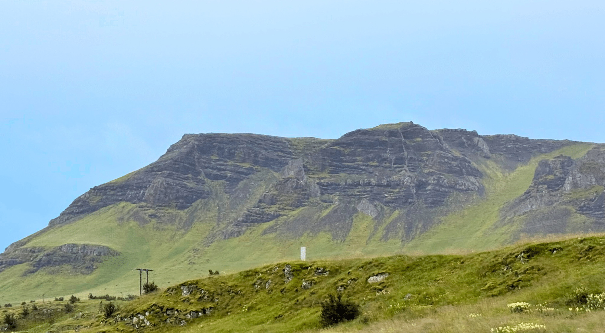 Mountain plateau with a grassy slope leading upward, symbolizing breaking through a Federal contracting growth stall
