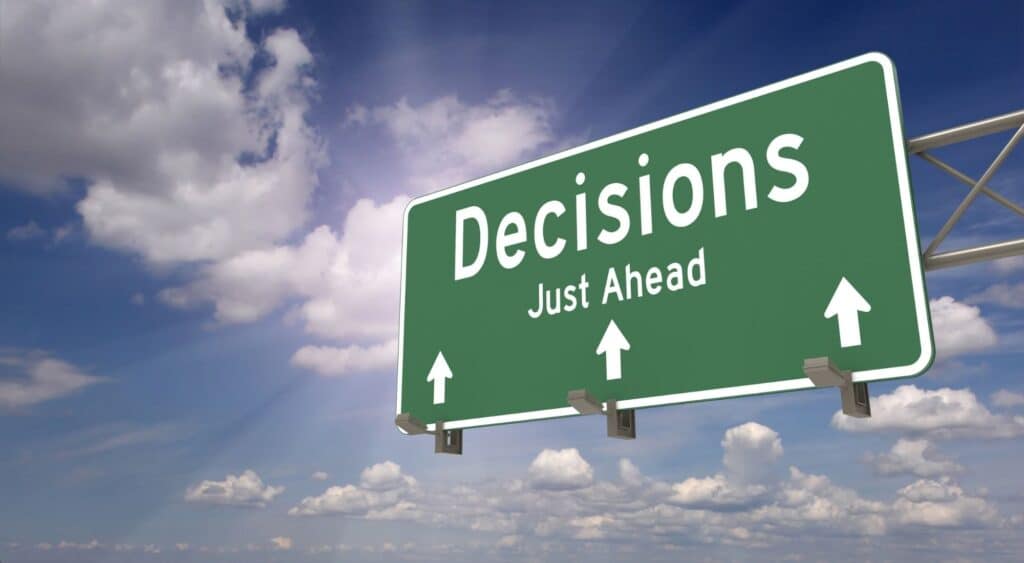 “Road sign with the words ‘Decisions Just Ahead’ against a blue sky — symbolizing the FY26 GSA Schedule decision guide for small businesses.